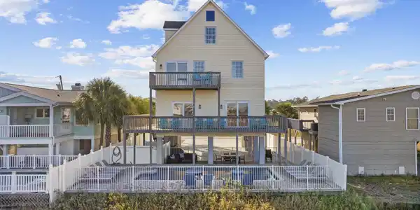 Image 2: Rear view of house with a fenced backyard, stairwa