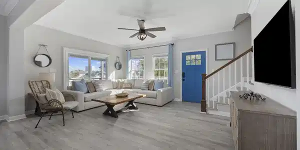 Image 4: Living room with stairway, crown molding, light wo