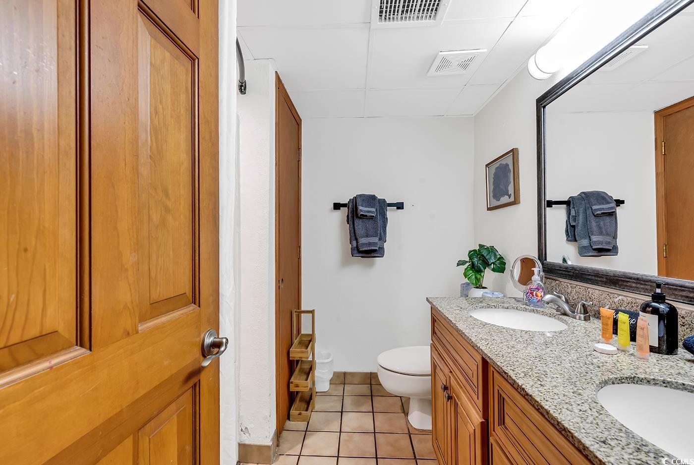 Image 4: Bathroom with tile patterned floors, vanity, and t