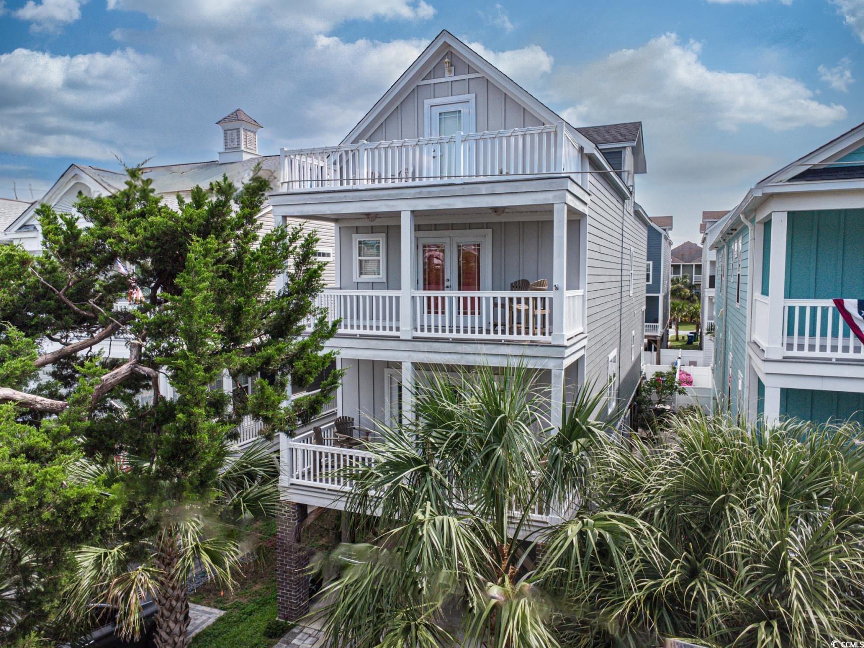 Image 1: Beach home with a balcony, board and batten siding