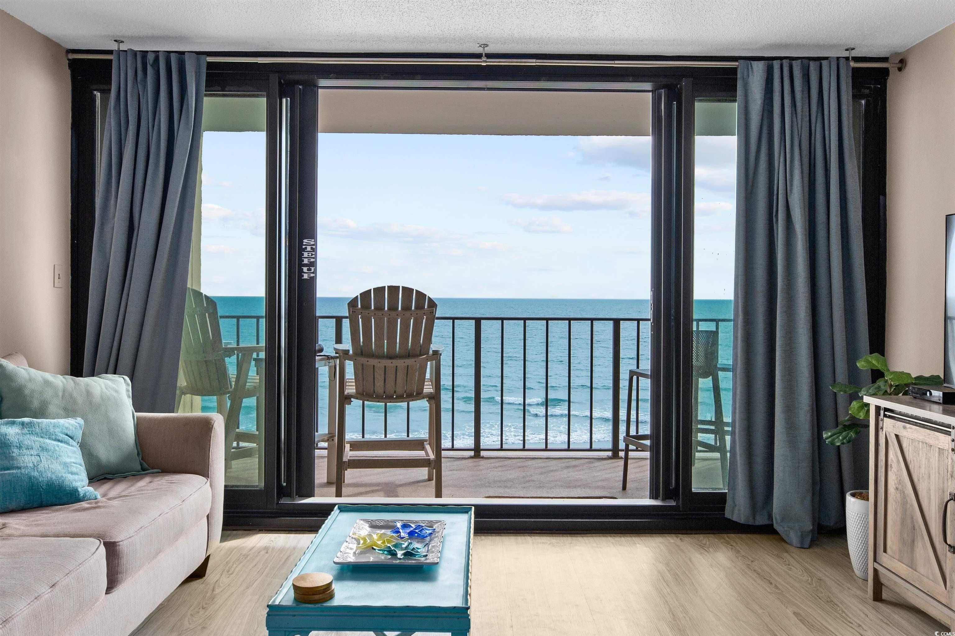 Image 3: Living area featuring expansive windows, light woo Image 3: Living area featuring expansive windows, light woo
