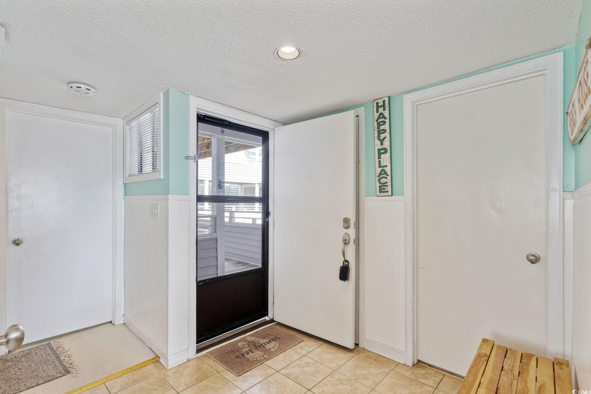 Image 3: Foyer entrance with a textured ceiling, a wainscot Image 3: Foyer entrance with a textured ceiling, a wainscot
