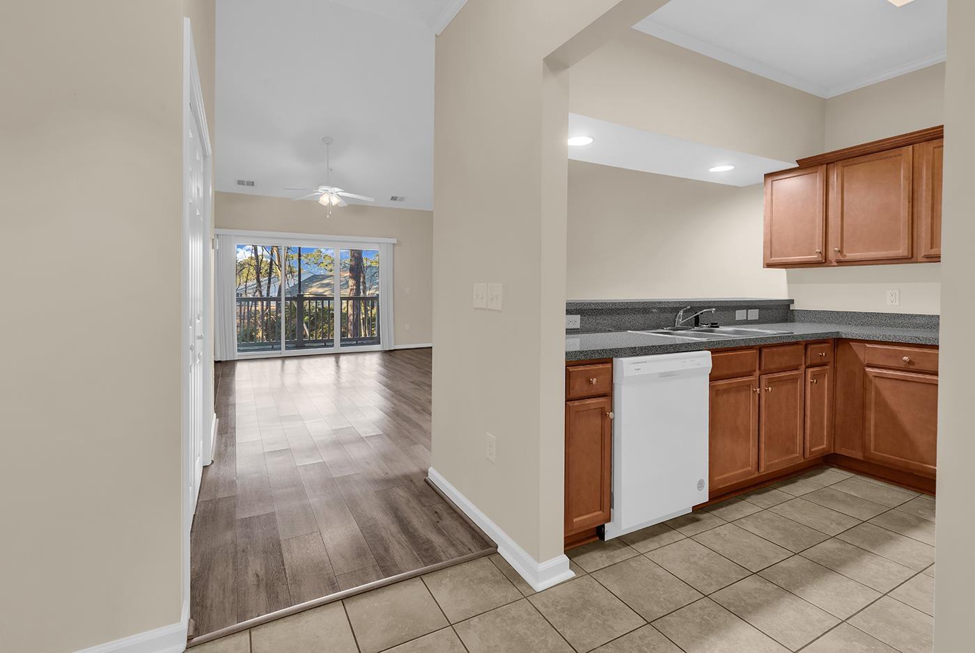 Image 2: Kitchen with brown cabinetry, white dishwasher, li