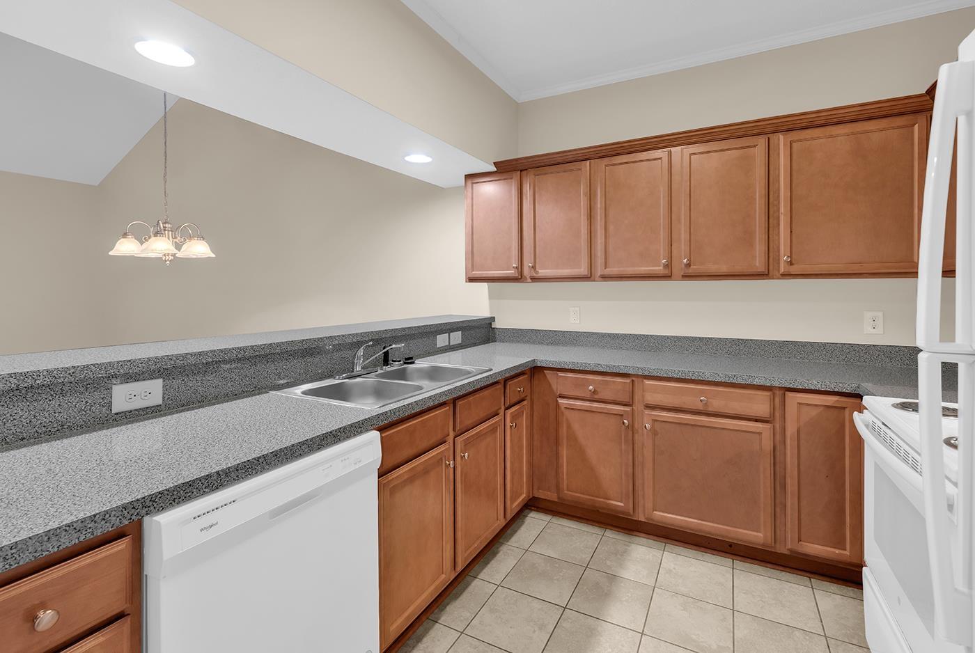 Image 3: Kitchen featuring white appliances, brown cabinets