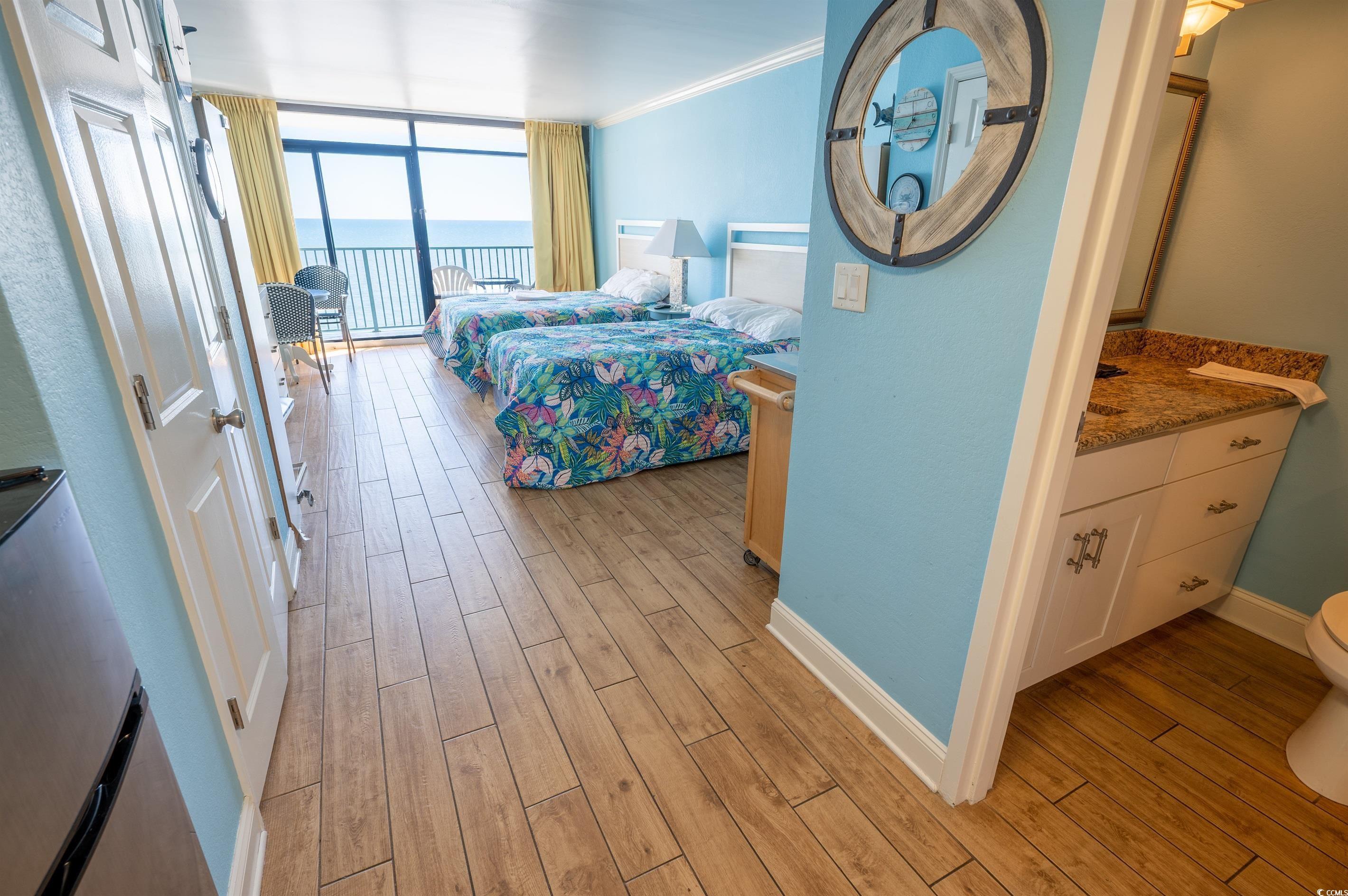 Image 4: Bedroom featuring expansive windows, light wood-ty Image 4: Bedroom featuring expansive windows, light wood-ty