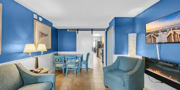 Image 3: Tiled living area featuring a barn door, a glass c