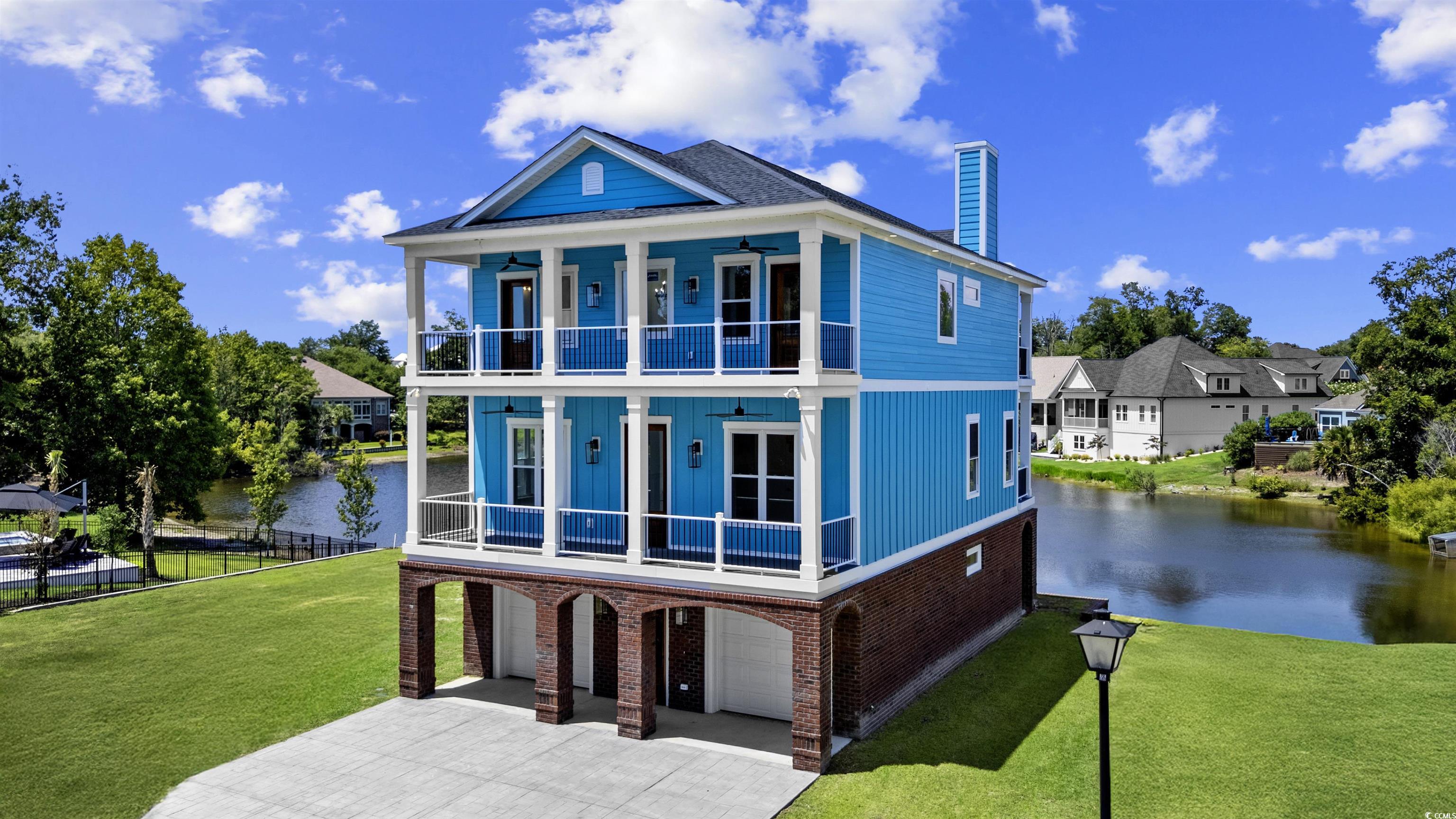 Image 1: Front of house with a balcony, a water view, a gar Image 1: Front of house with a balcony, a water view, a gar