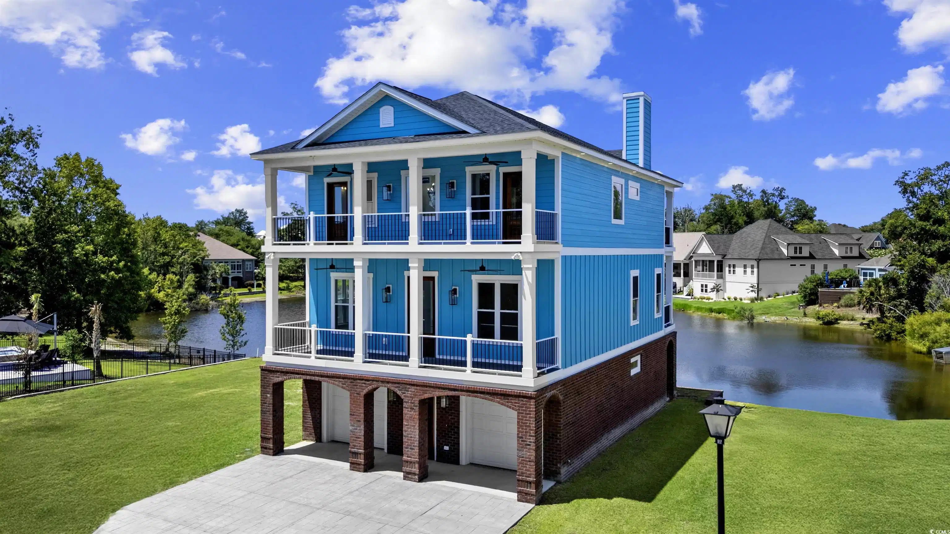 Image 1: Front of house with a balcony, a water view, a gar Image 1: Front of house with a balcony, a water view, a gar