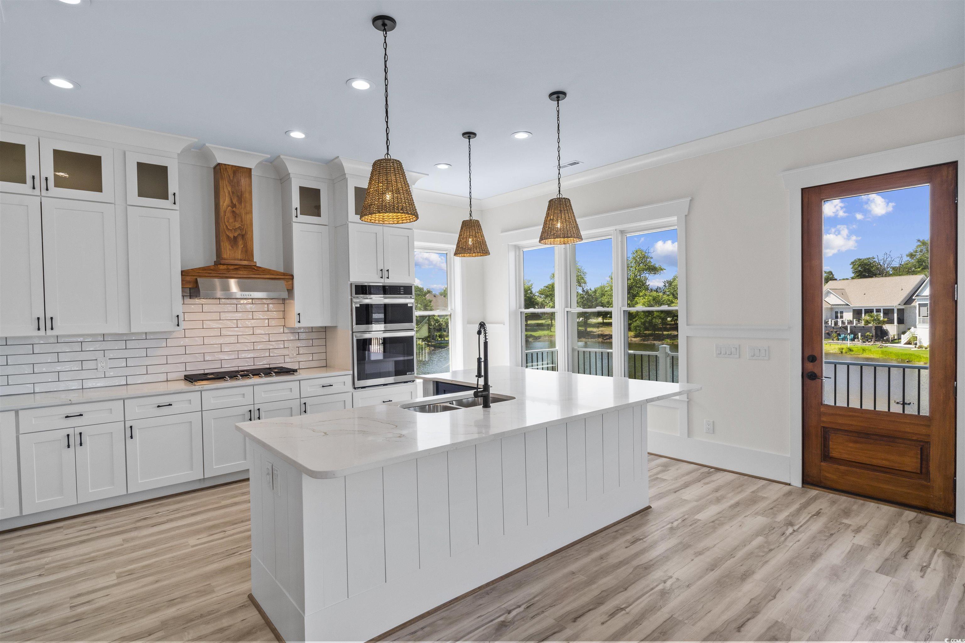 Image 3: Kitchen with backsplash, light wood finished floor Image 3: Kitchen with backsplash, light wood finished floor