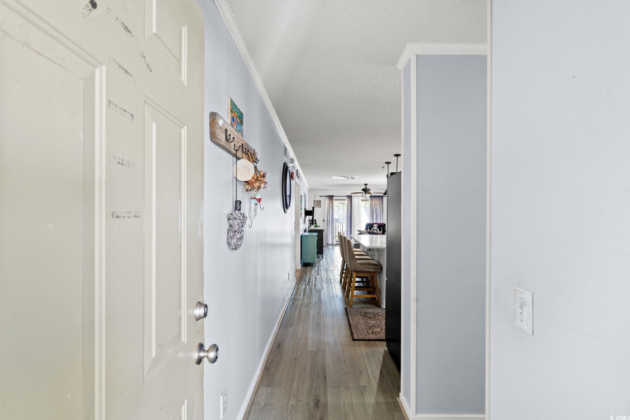 Image 3: Hall with ornamental molding and wood finished flo