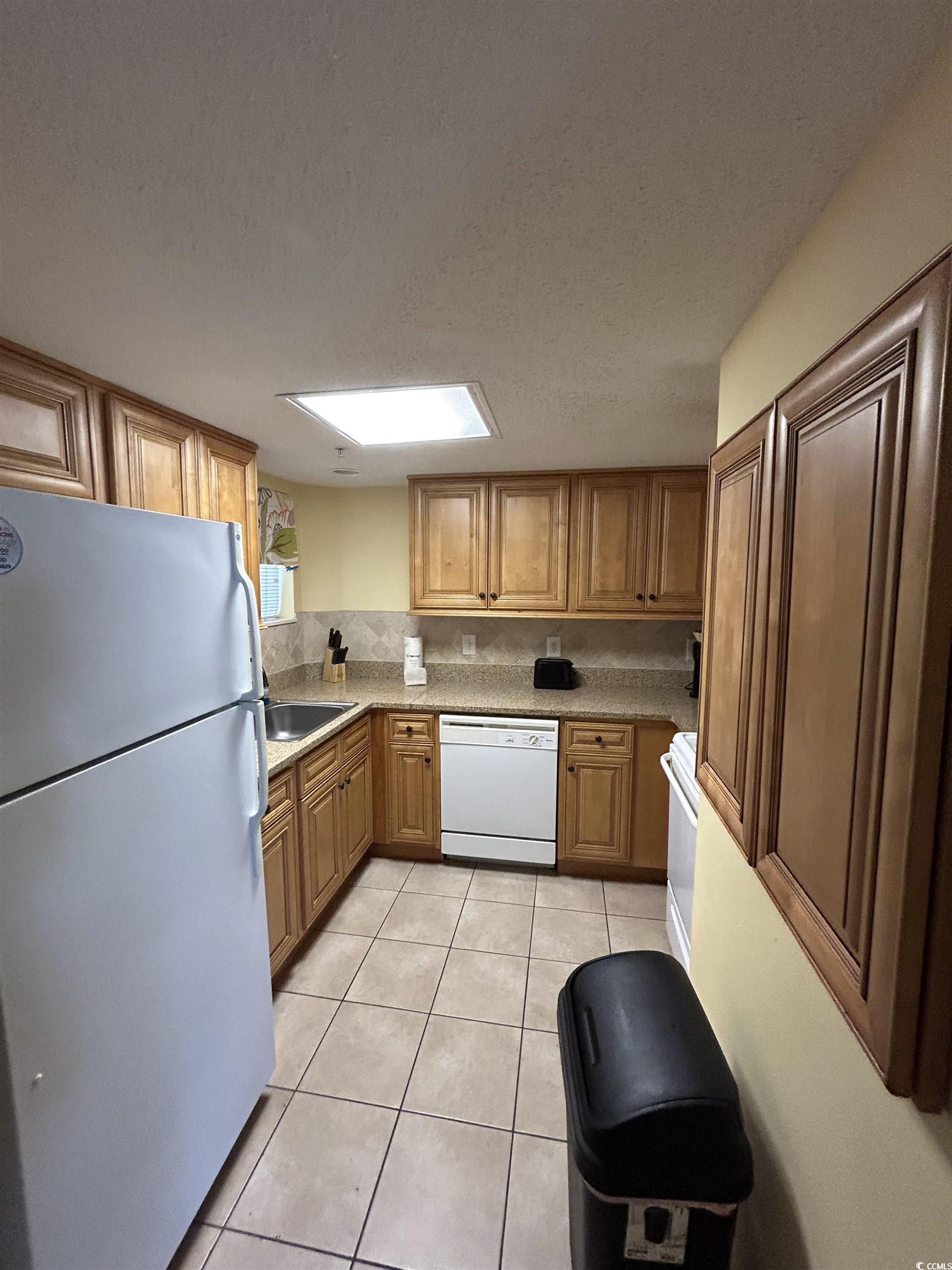 Image 4: Kitchen featuring a skylight, white appliances, a Image 4: Kitchen featuring a skylight, white appliances, a