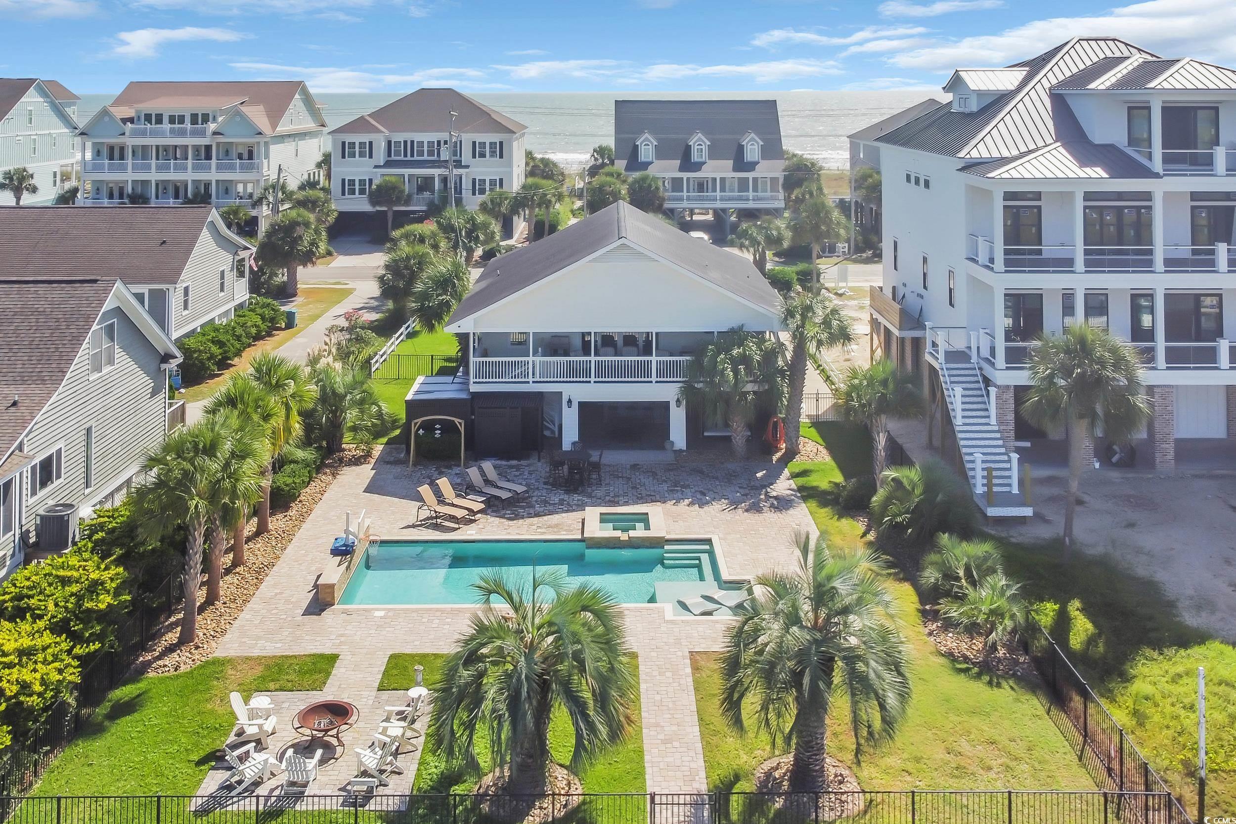 Image 2: Aerial view of residential area featuring a pool