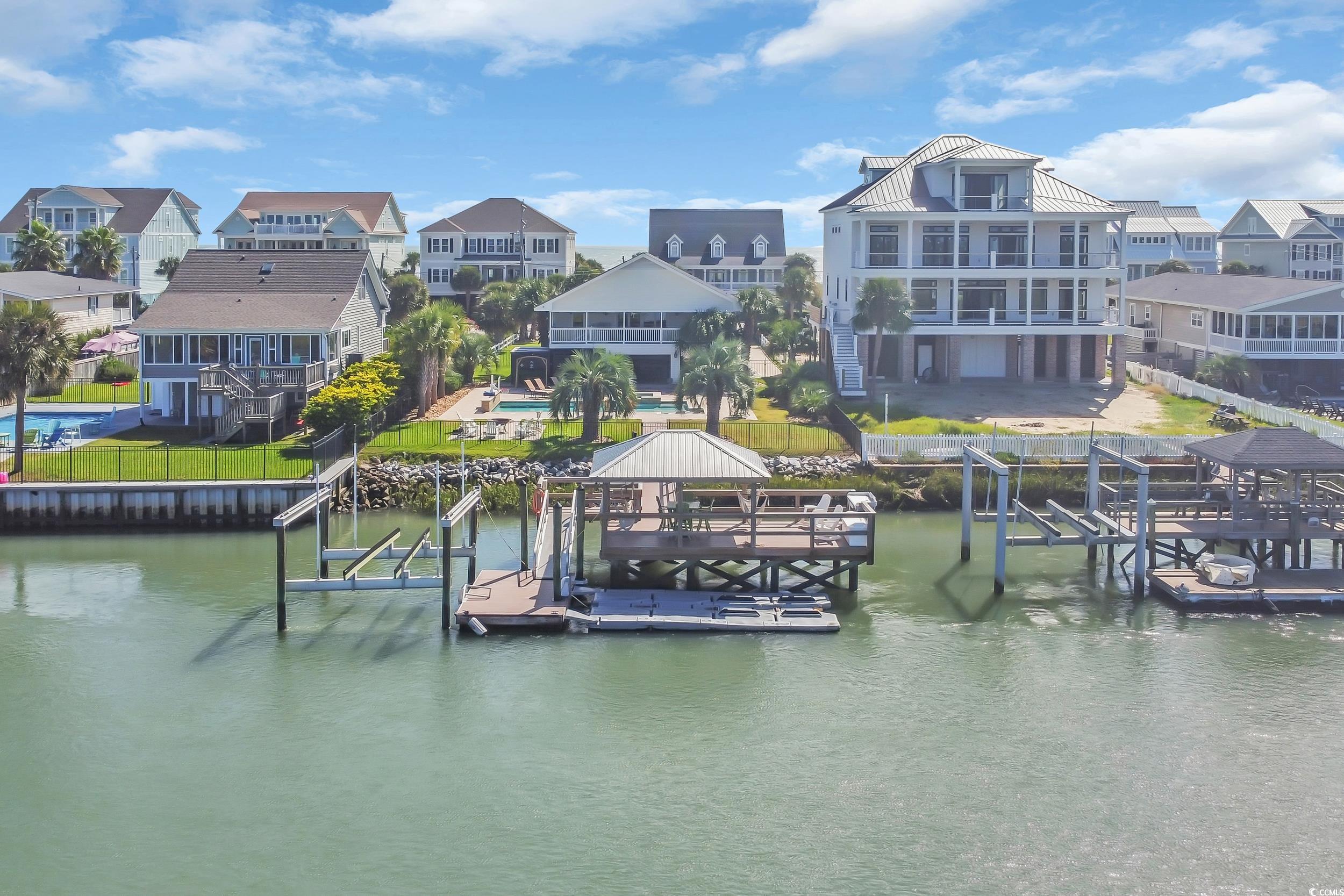 Image 3: Dock area with boat lift, a residential view, and