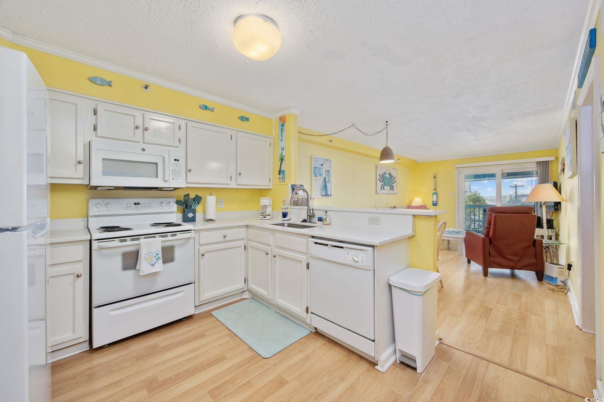 Image 3: Kitchen featuring a peninsula, white appliances, a Image 3: Kitchen featuring a peninsula, white appliances, a