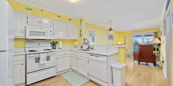 Image 3: Kitchen featuring a peninsula, white appliances, a