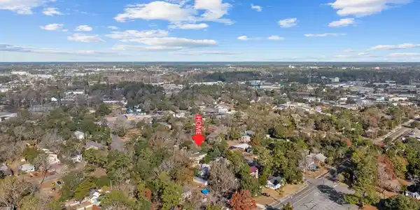 Image 2: Aerial view of property's location with a tree fil
