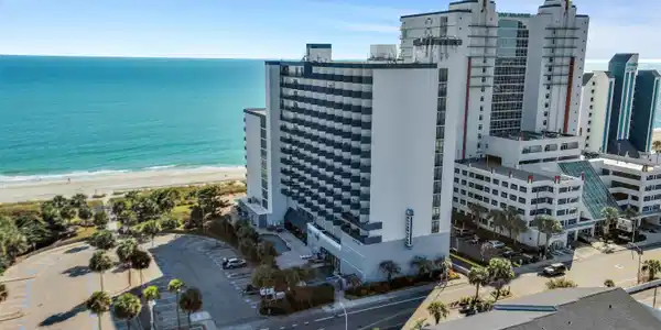 Image 3: Bird's eye view of expansive coastline and apartme