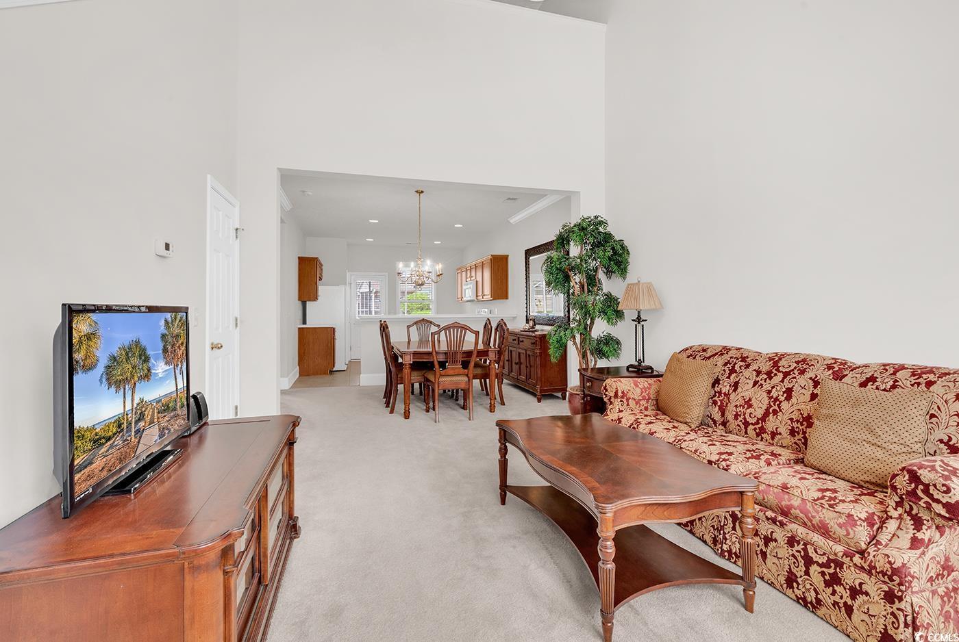 Image 3: Living area featuring a chandelier, light colored