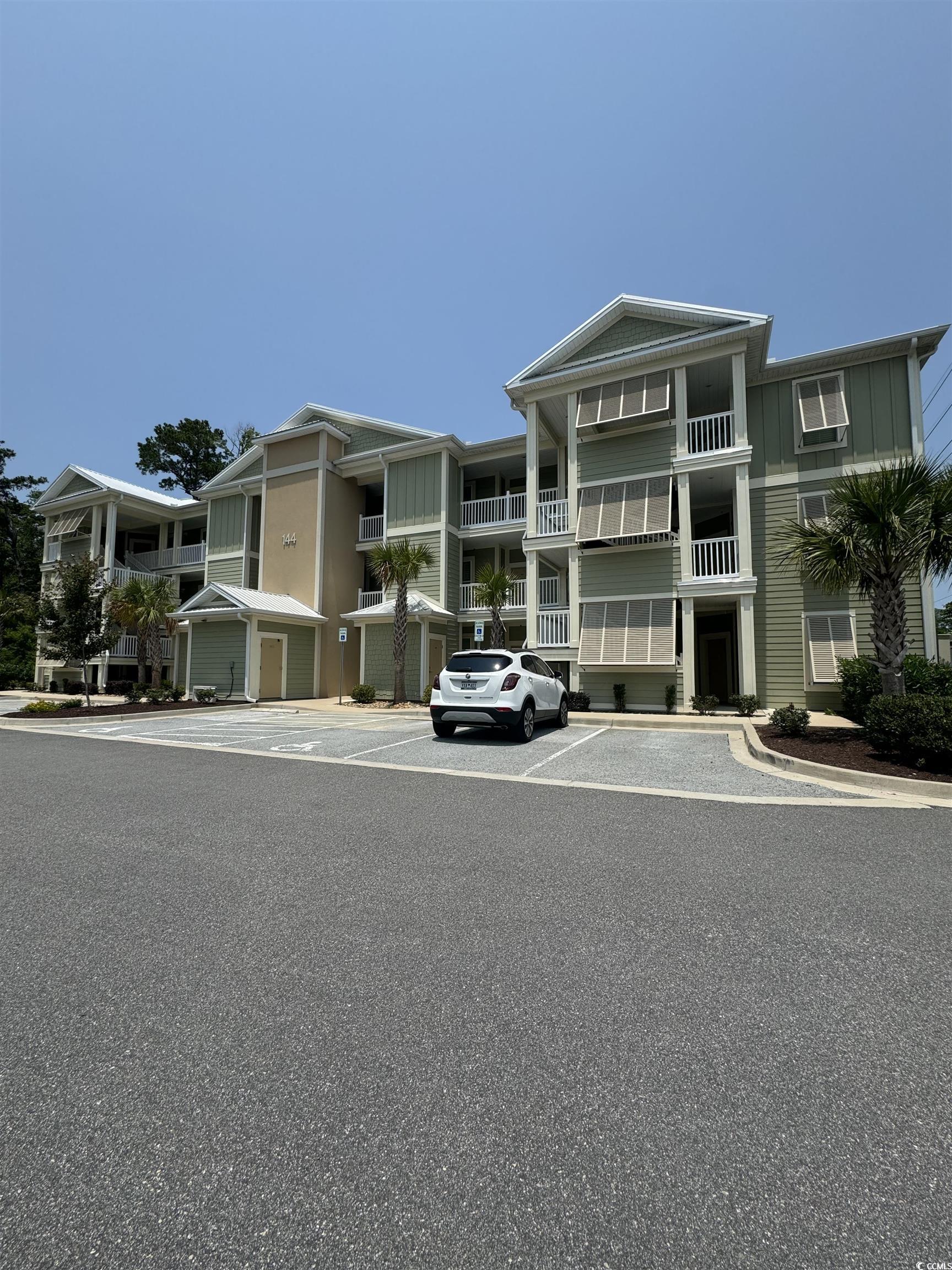 Image 1: View of front facade with uncovered parking