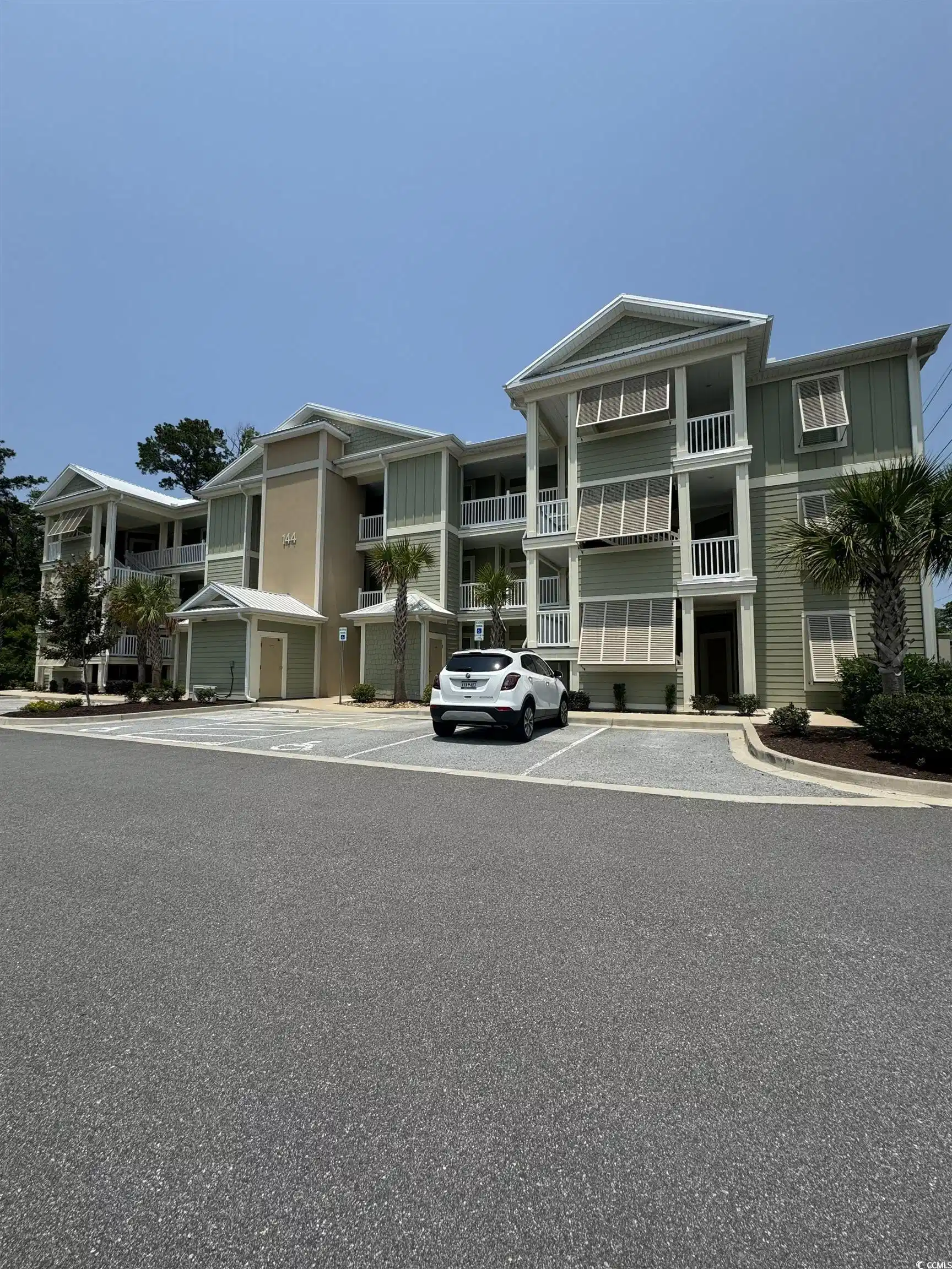 Image 1: View of front facade with uncovered parking