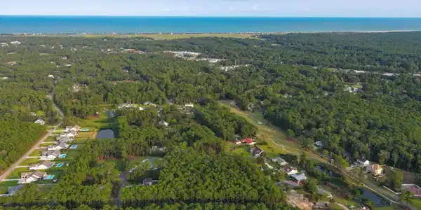 Image 2: View of property location featuring a forest and a