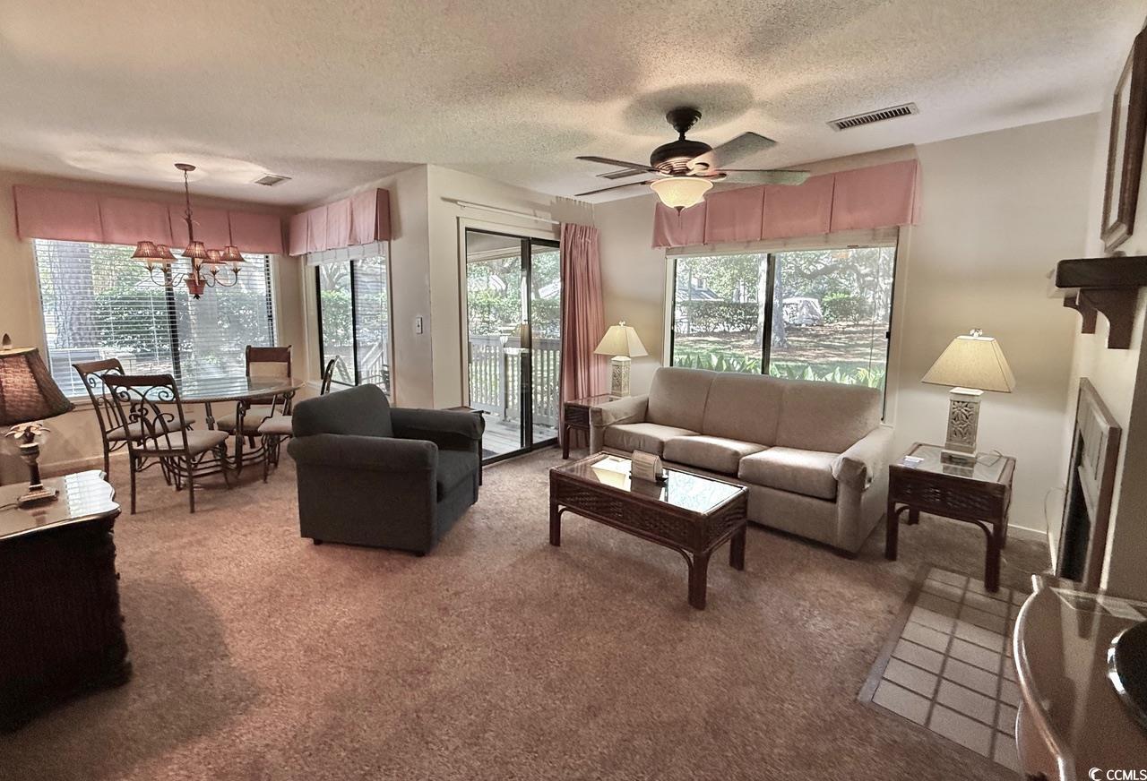 Image 4: Carpeted living area featuring a chandelier, a tex Image 4: Carpeted living area featuring a chandelier, a tex