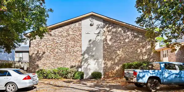Image 2: View of home's exterior with uncovered parking and