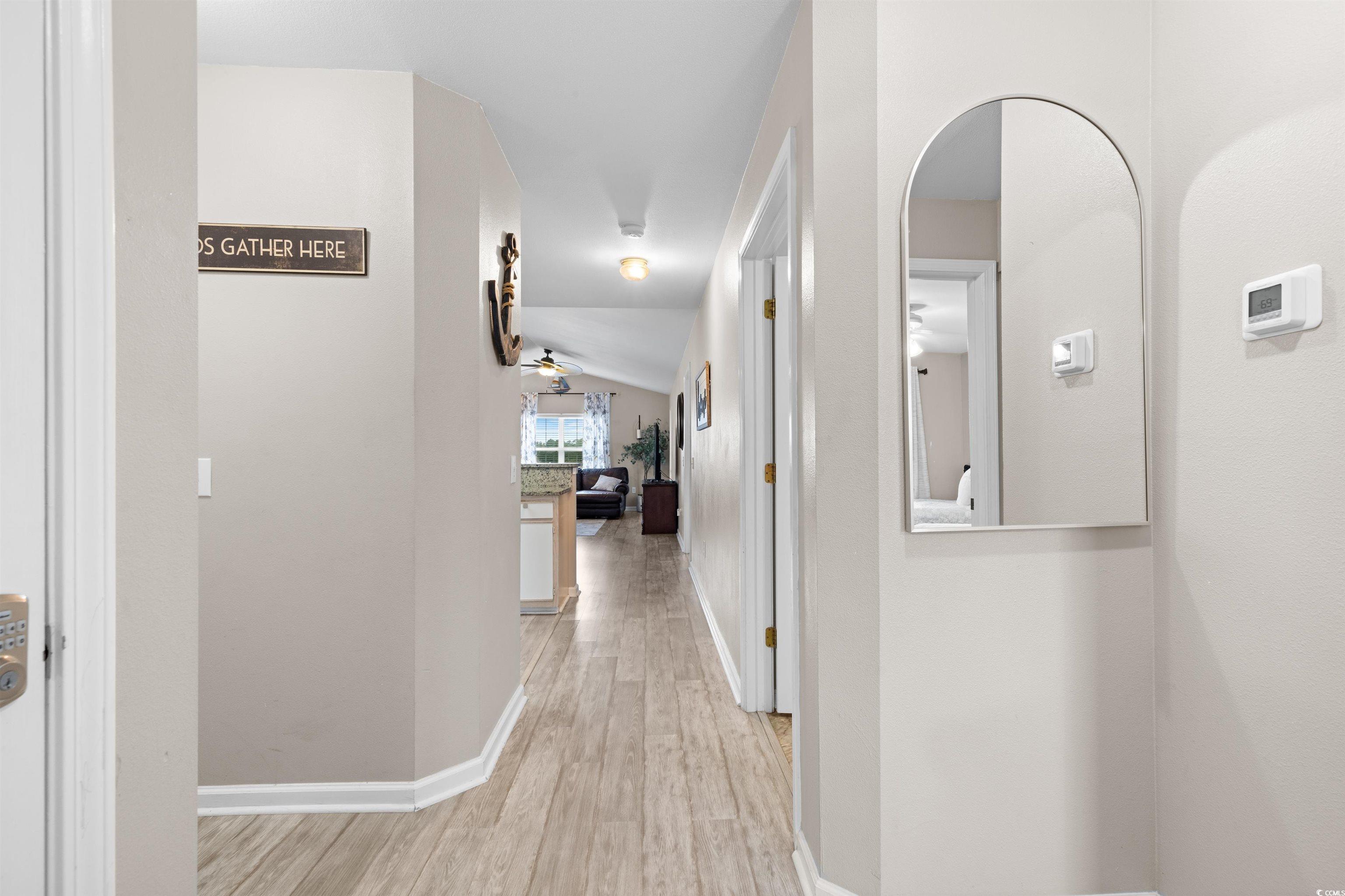 Image 2: Corridor with light wood finished floors, arched w