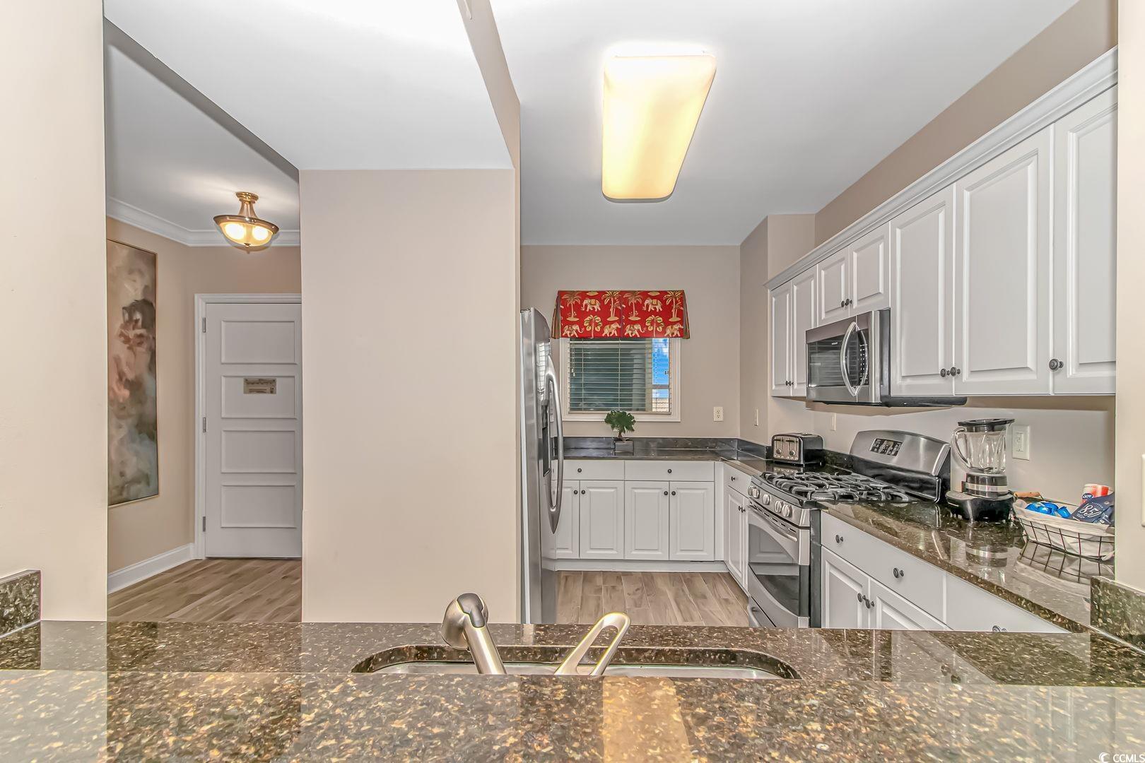 Image 4: Kitchen with dark stone countertops, stainless ste Image 4: Kitchen with dark stone countertops, stainless ste