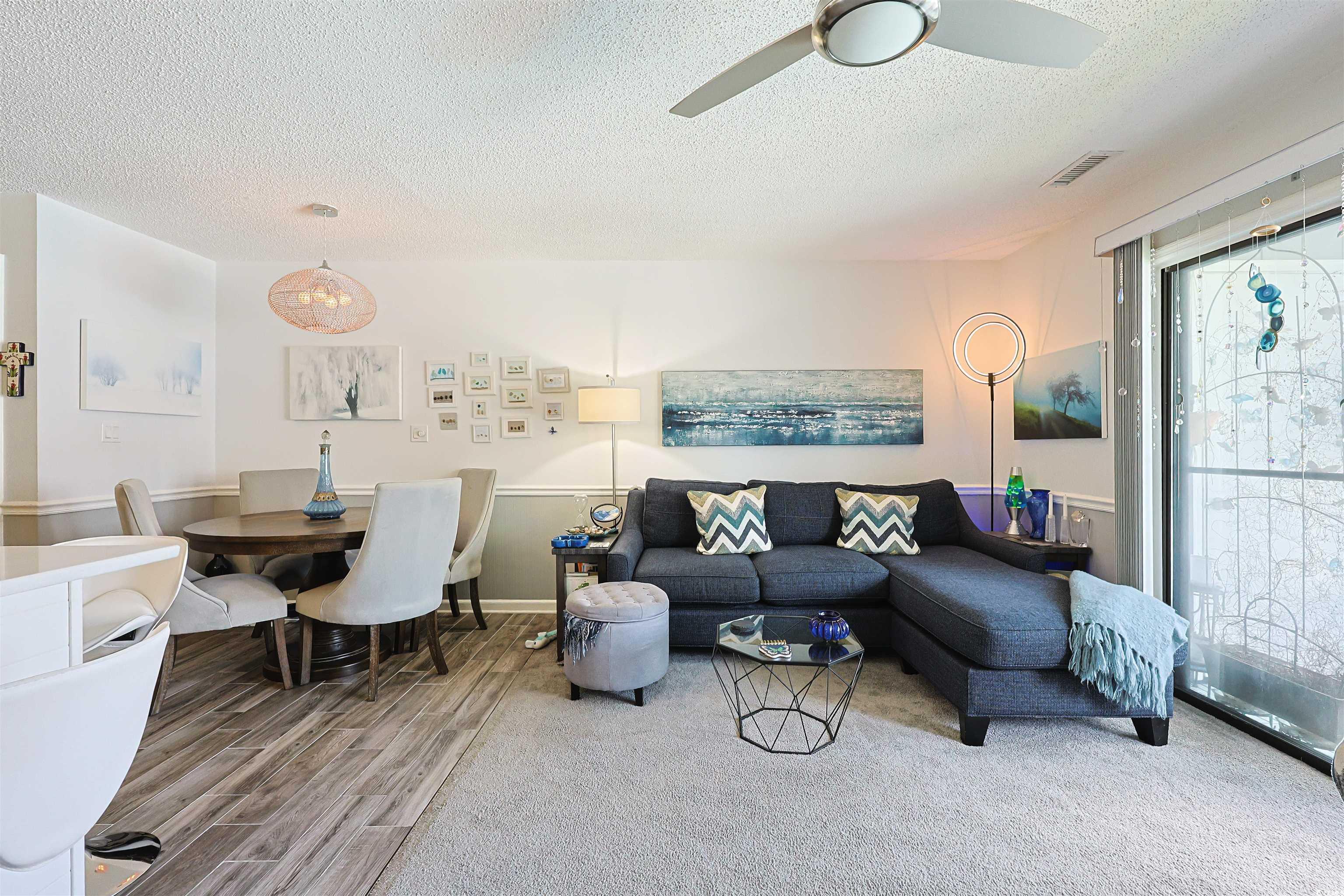 Image 4: Living area featuring a textured ceiling and wood