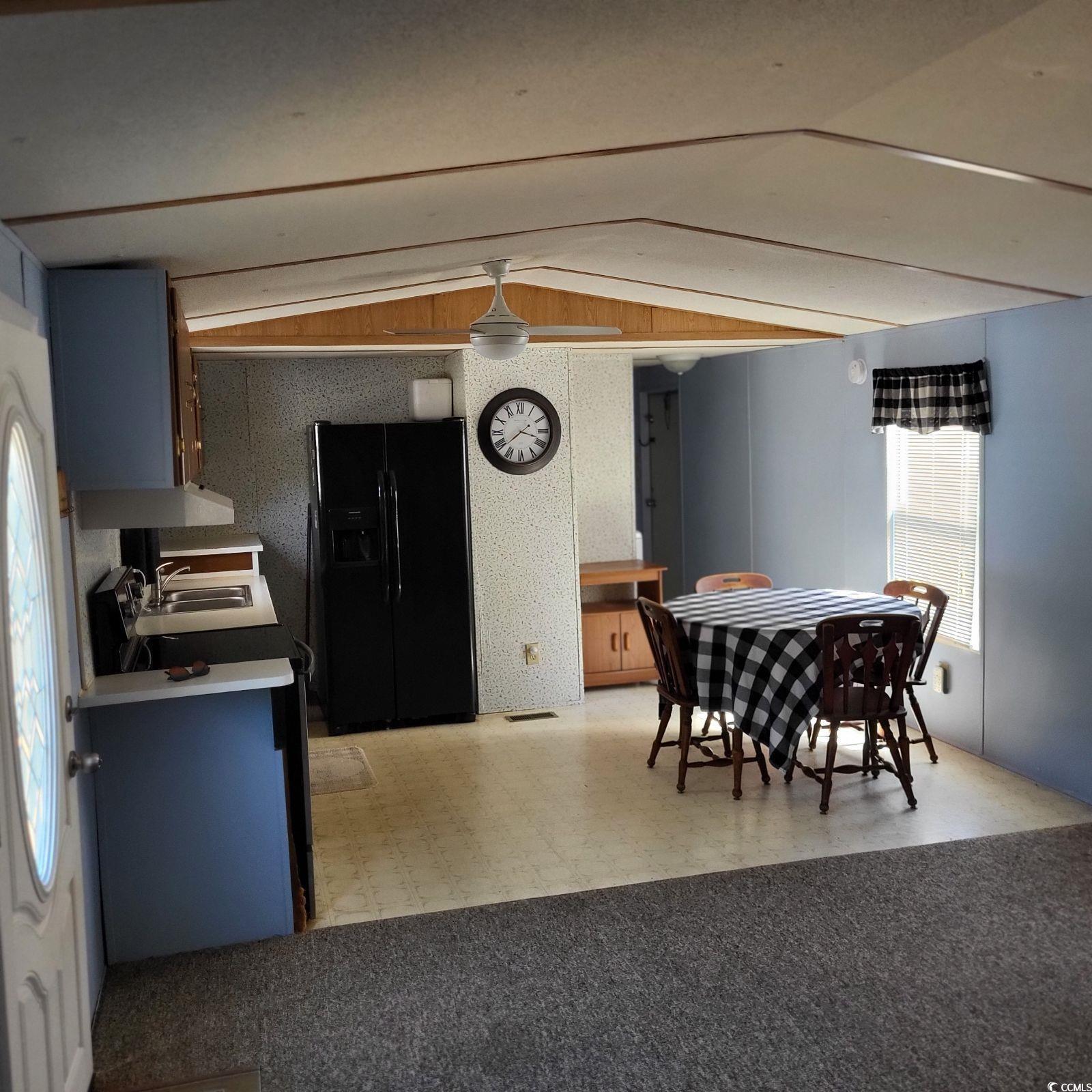Image 3: Kitchen with lofted ceiling, black fridge with ice