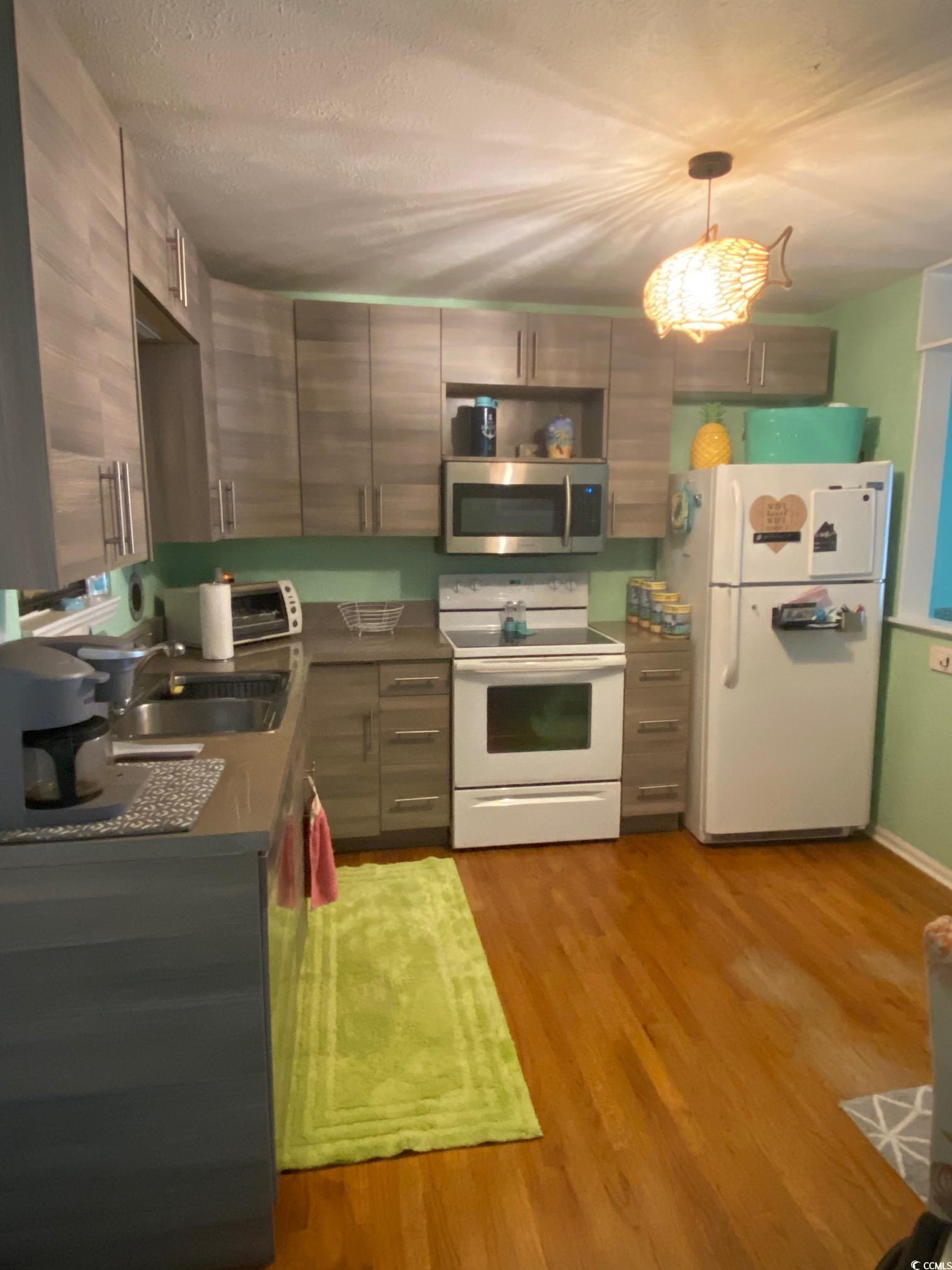 Image 3: Kitchen featuring white appliances, decorative lig