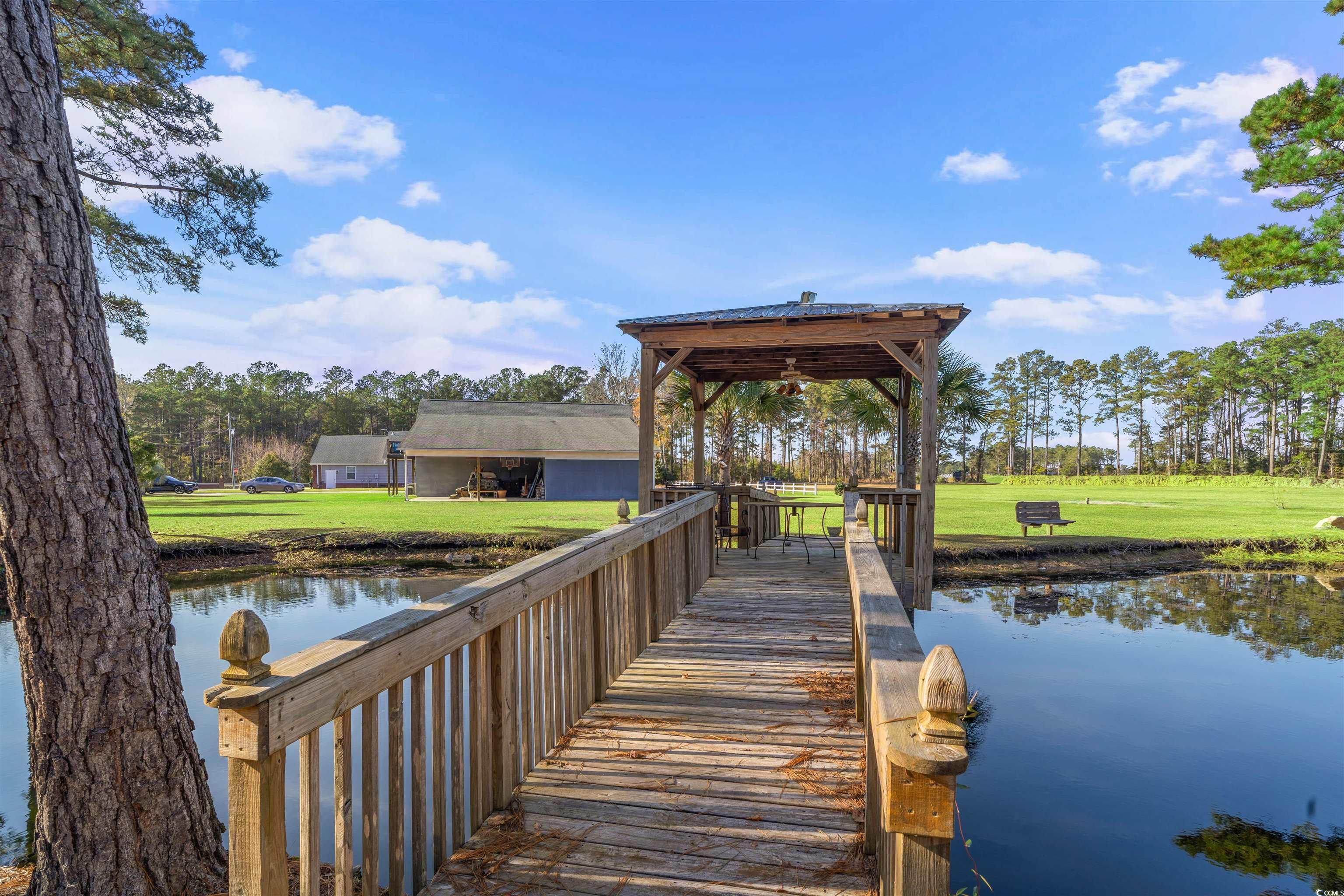 Image 2: Dock area featuring a lawn and a water view