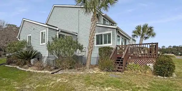 Image 3: View of side of home with a lawn and a wooden deck