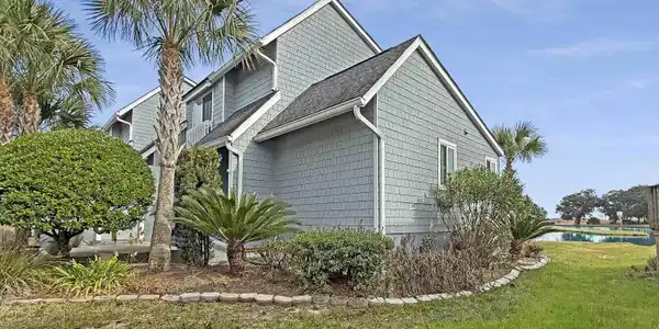 Image 4: View of home's exterior with a lawn and roof with