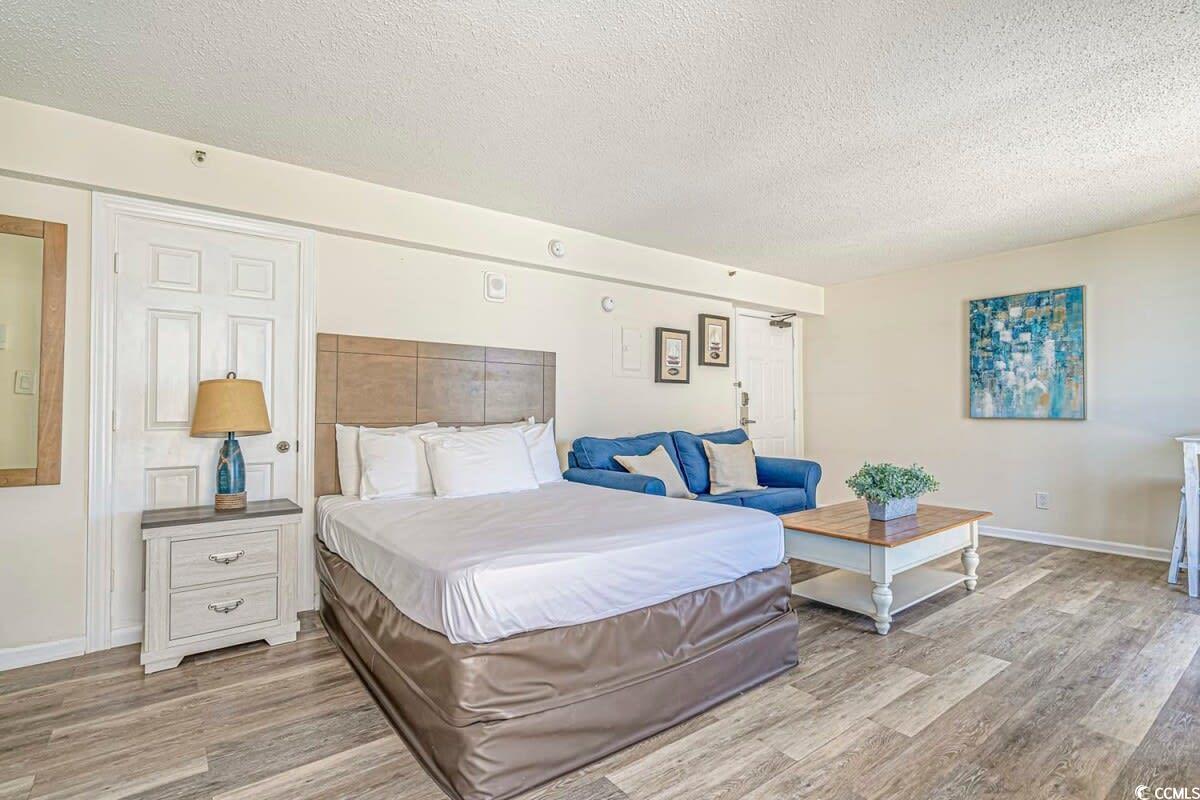 Image 2: Bedroom with baseboards, a textured ceiling, and w