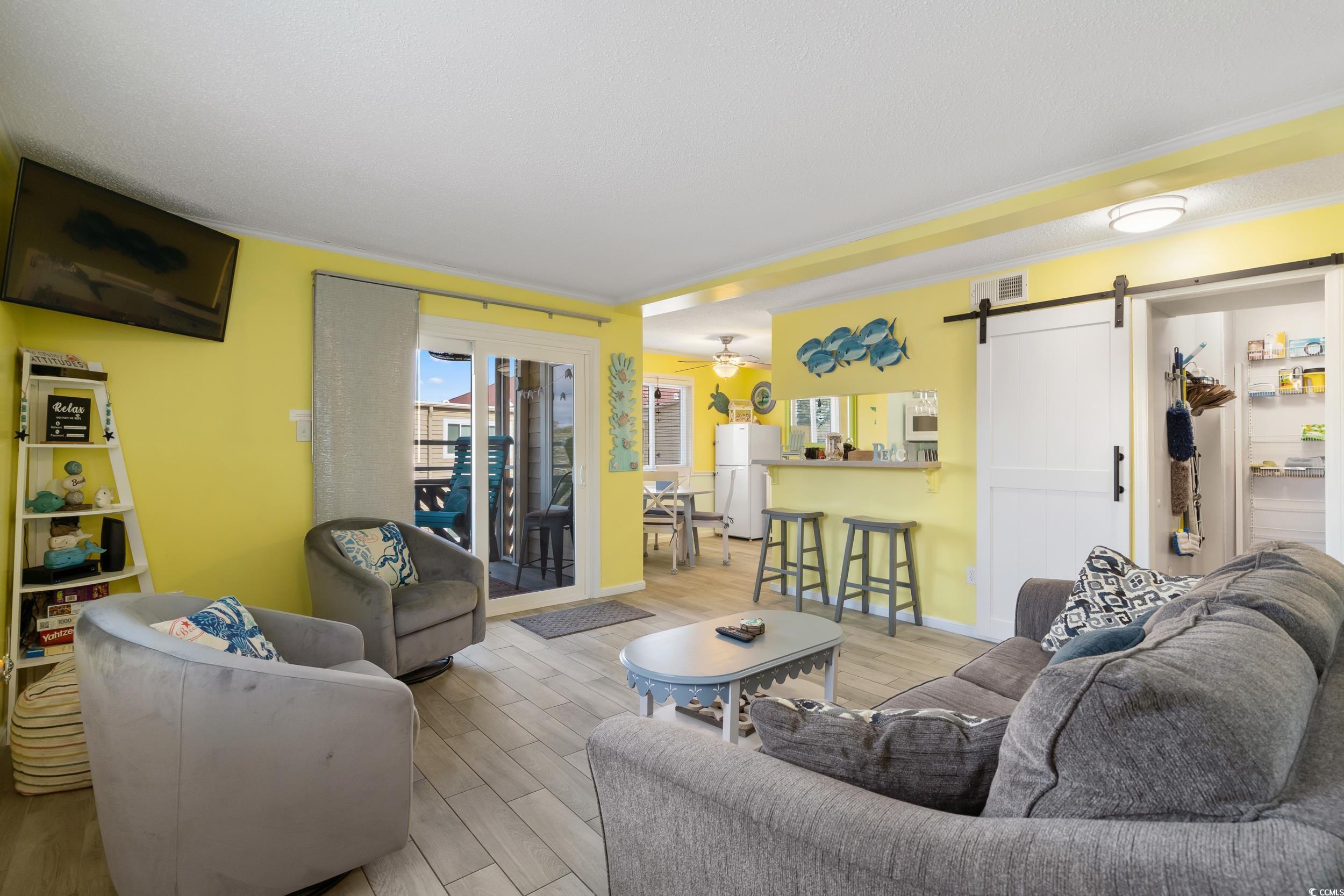 Image 4: Living room with a barn door, ceiling fan, light h Image 4: Living room with a barn door, ceiling fan, light h