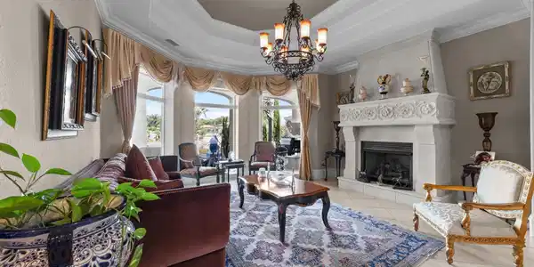 Image 3: Living area featuring a tray ceiling, a chandelier