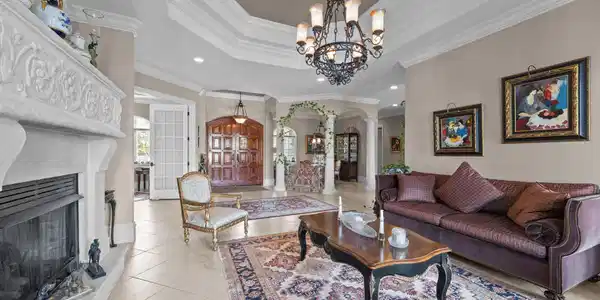 Image 4: Living room featuring a tray ceiling, arched walkw
