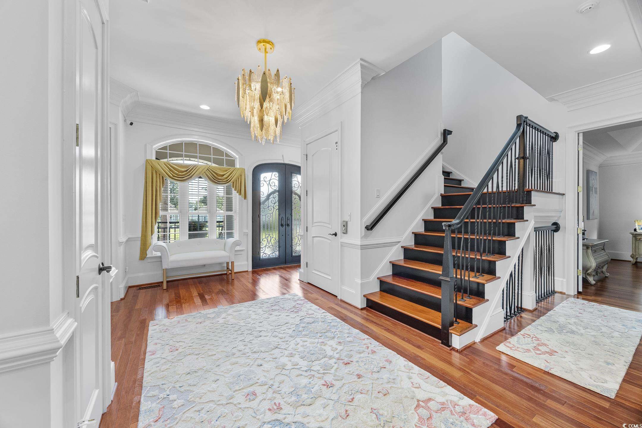 Image 3: Entrance foyer featuring ornamental molding, wood