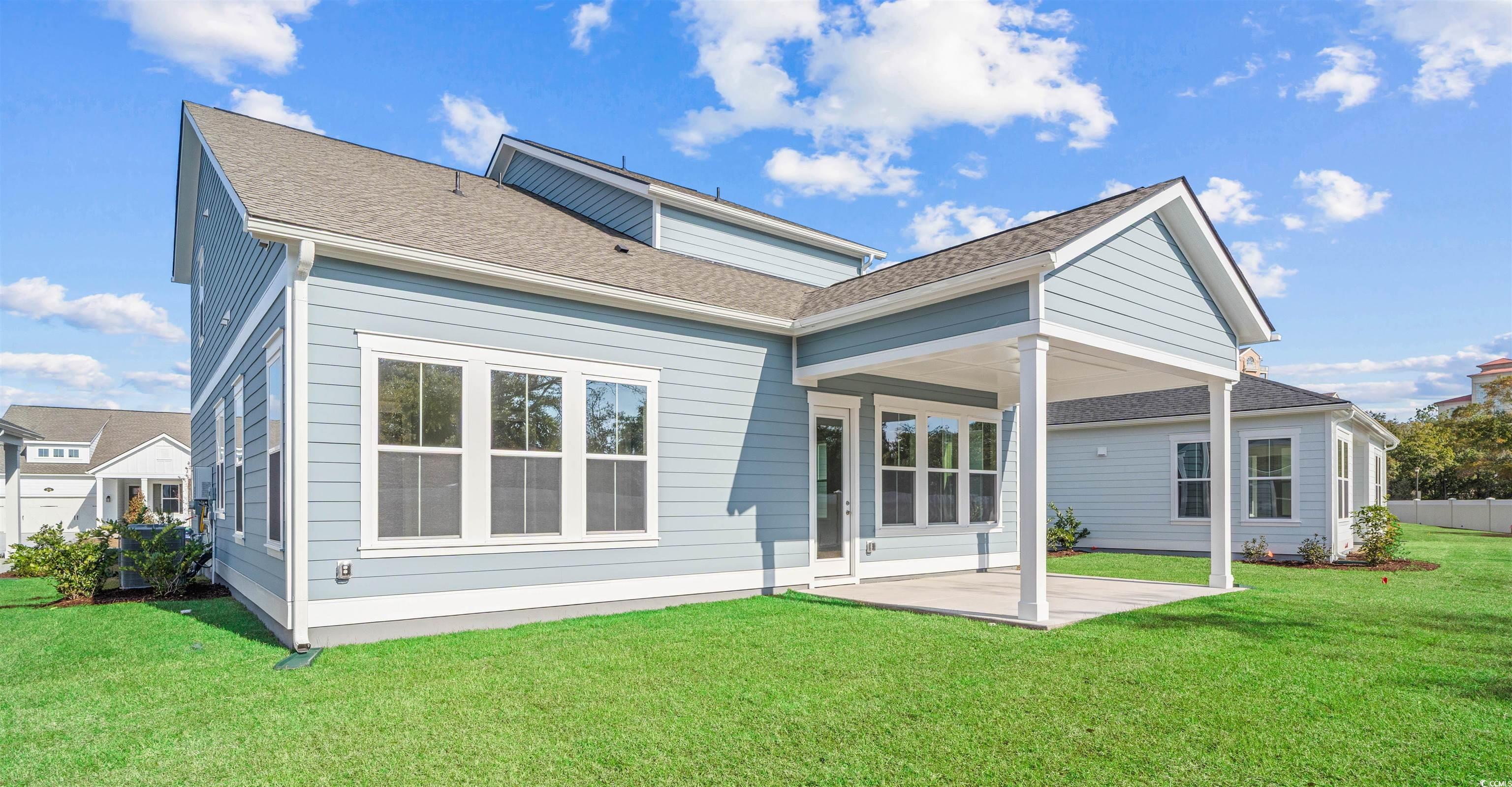Image 4: Back of house with a patio area, a yard, and roof Image 4: Back of house with a patio area, a yard, and roof