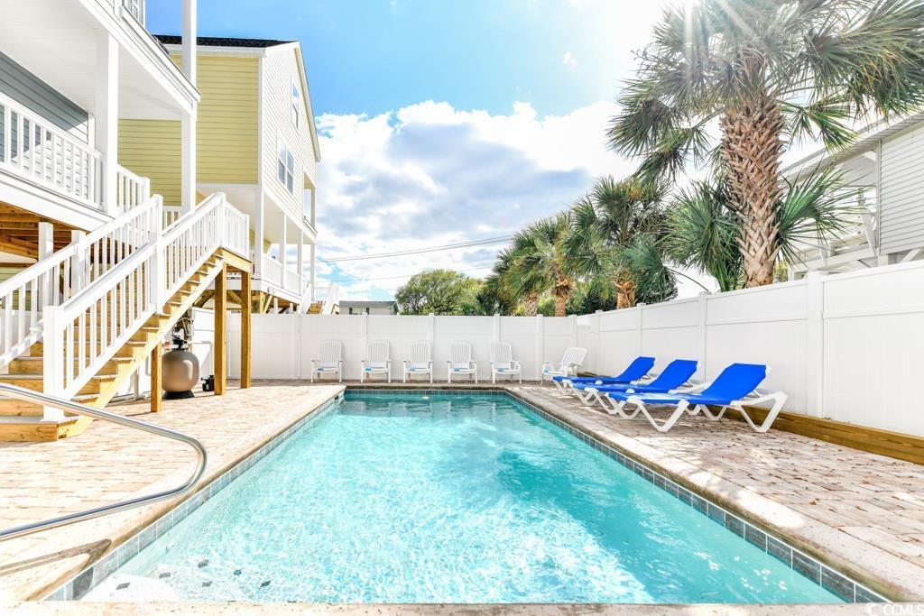 Image 2: View of pool with a fenced in pool, stairway, a fe