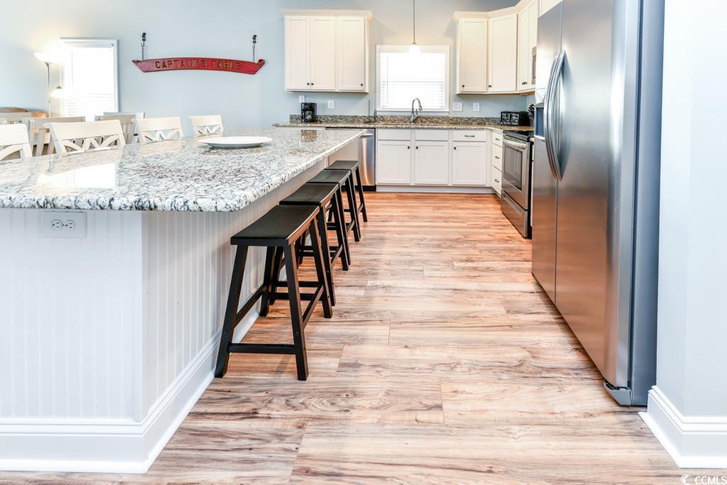 Image 3: Kitchen with a sink, light wood-style floors, appl