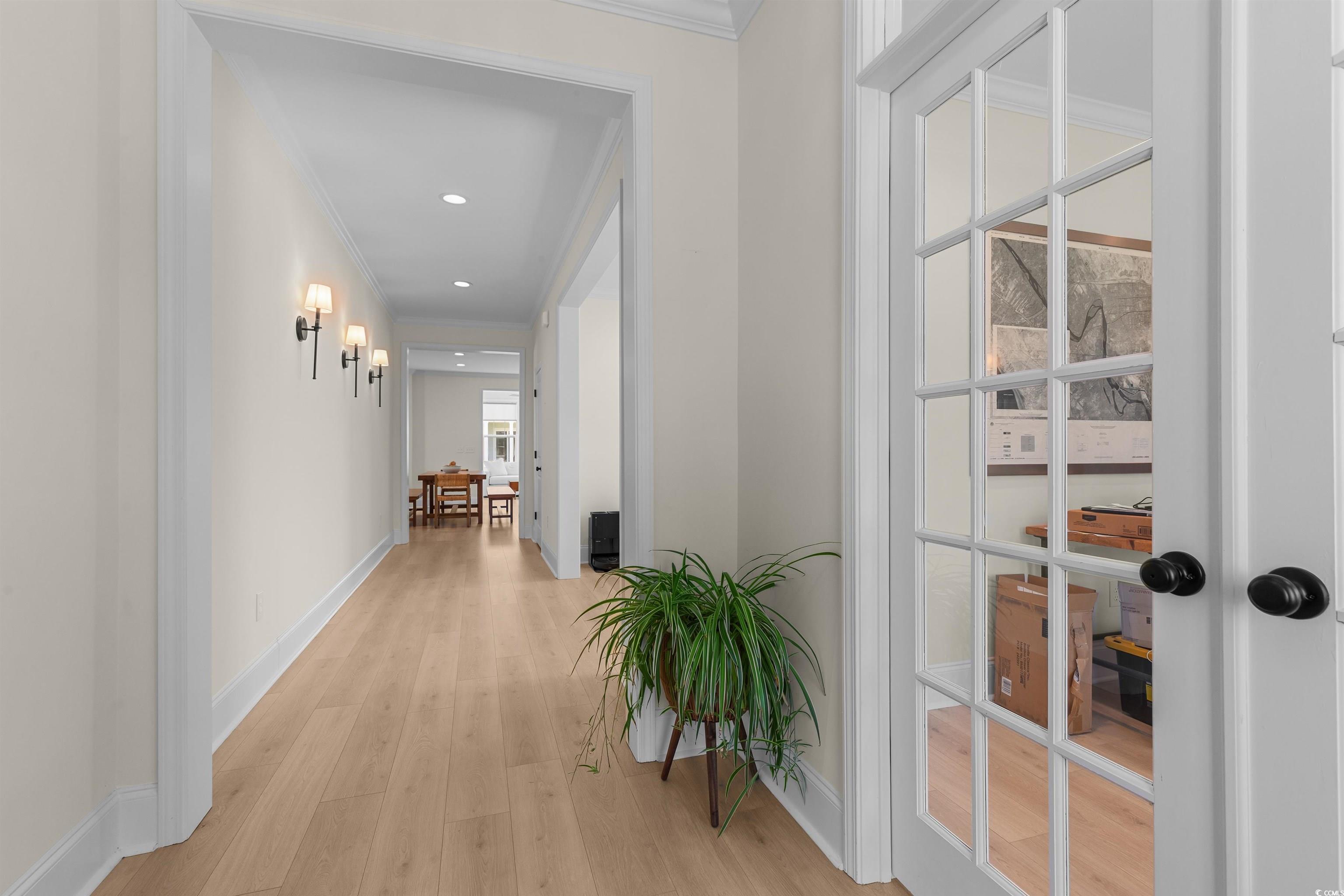 Image 3: Hall featuring light wood finished floors, crown m