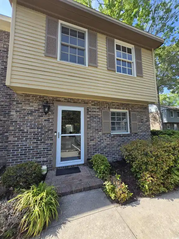 Image 1: View of exterior entry with brick siding