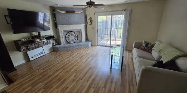 Image 2: Living room with wood finished floors, a textured