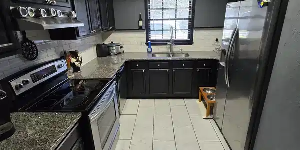 Image 4: Kitchen with dark cabinets, appliances with stainl