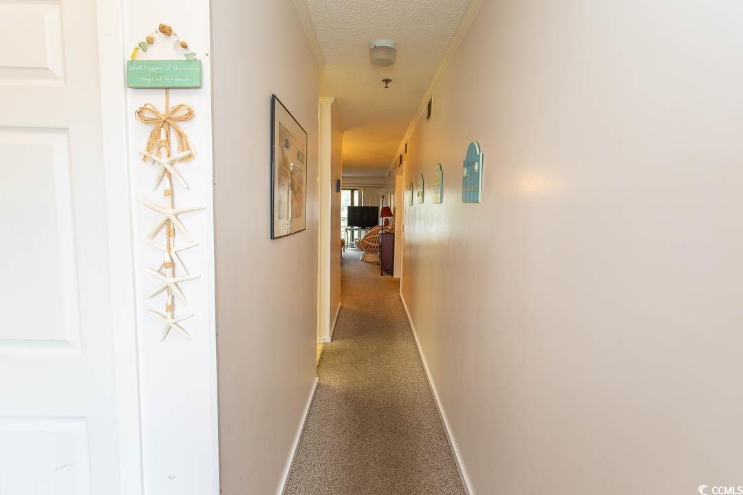 Image 2: Corridor featuring baseboards, carpet flooring, an Image 2: Corridor featuring baseboards, carpet flooring, an