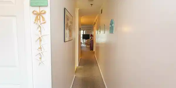 Image 2: Corridor featuring baseboards, carpet flooring, an