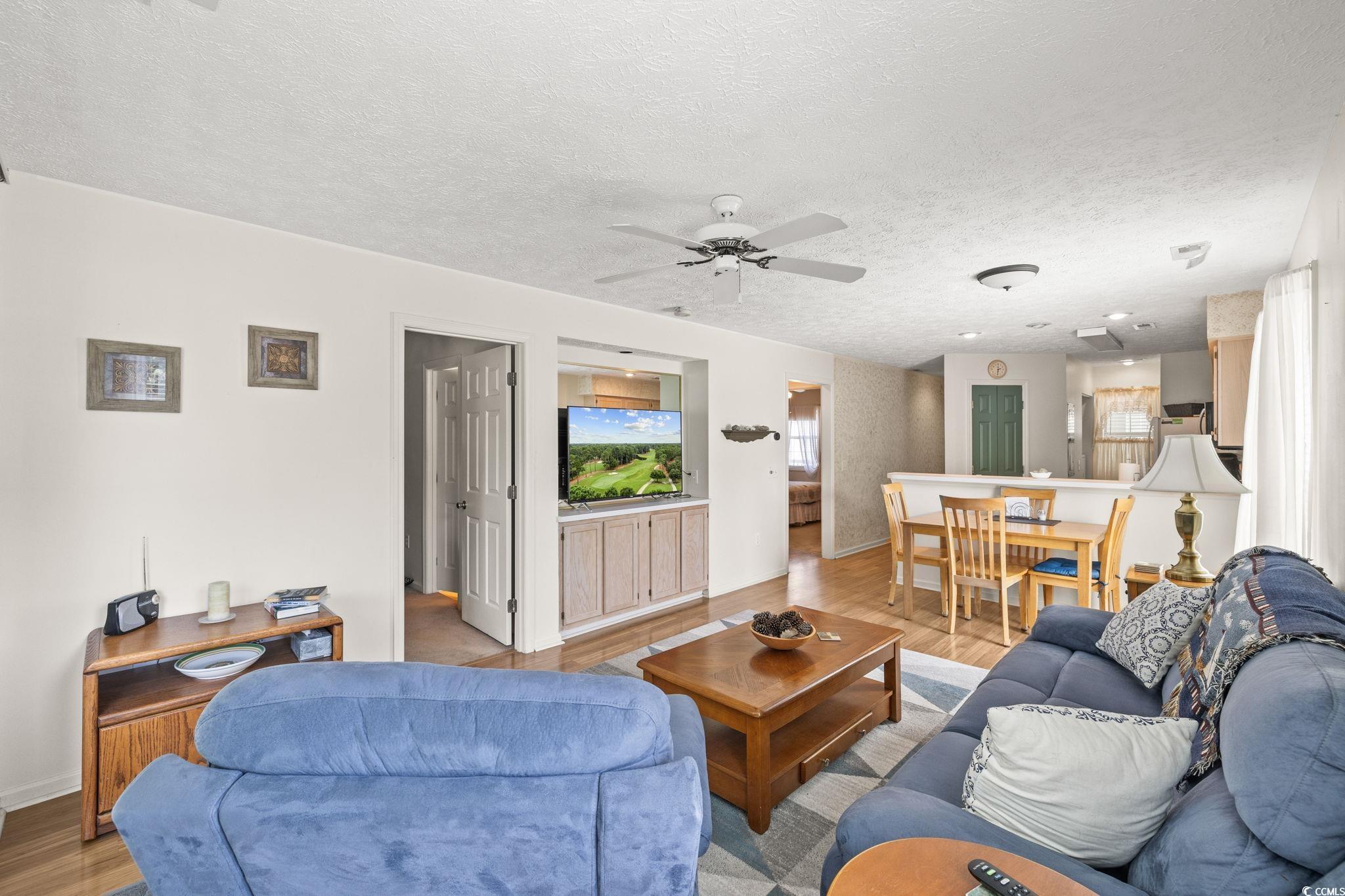 Image 4: Living area with light wood-style floors, a ceilin